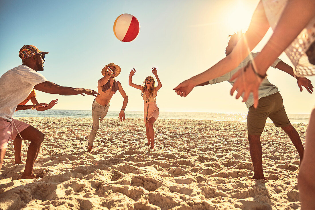 Playful young friends playing with beach ball