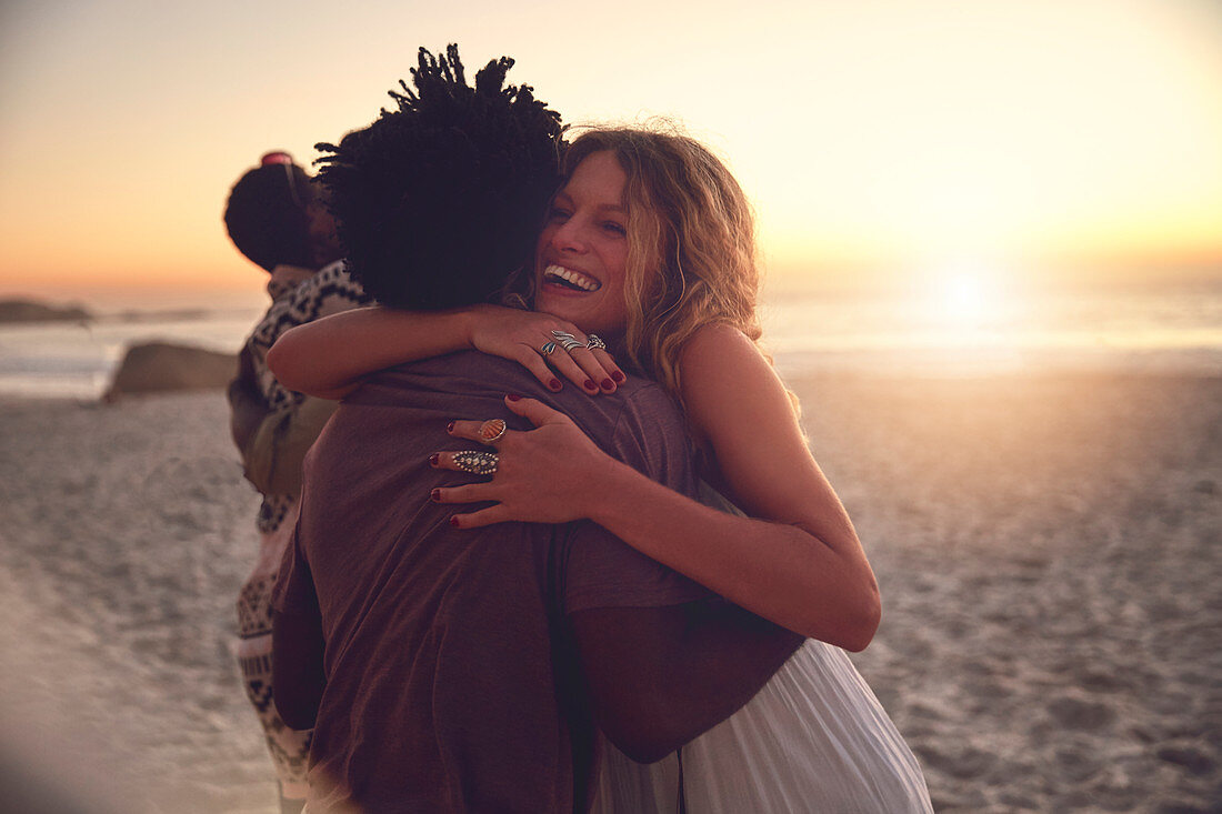 Affectionate couple hugging on sunset summer beach