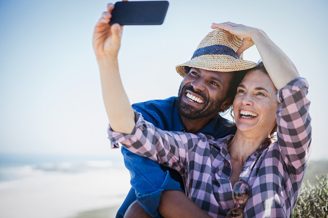 Playful couple taking selfie with camera phone