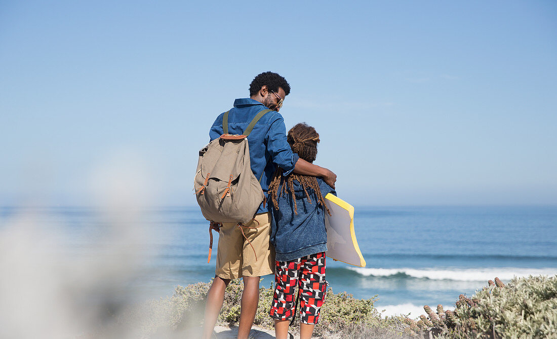 Father and son walking with boogie board