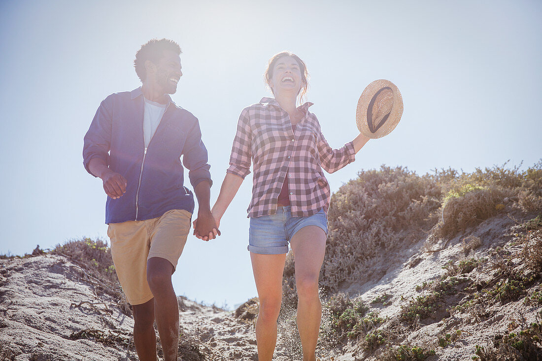 Multi-ethnic couple walking, holding hands path