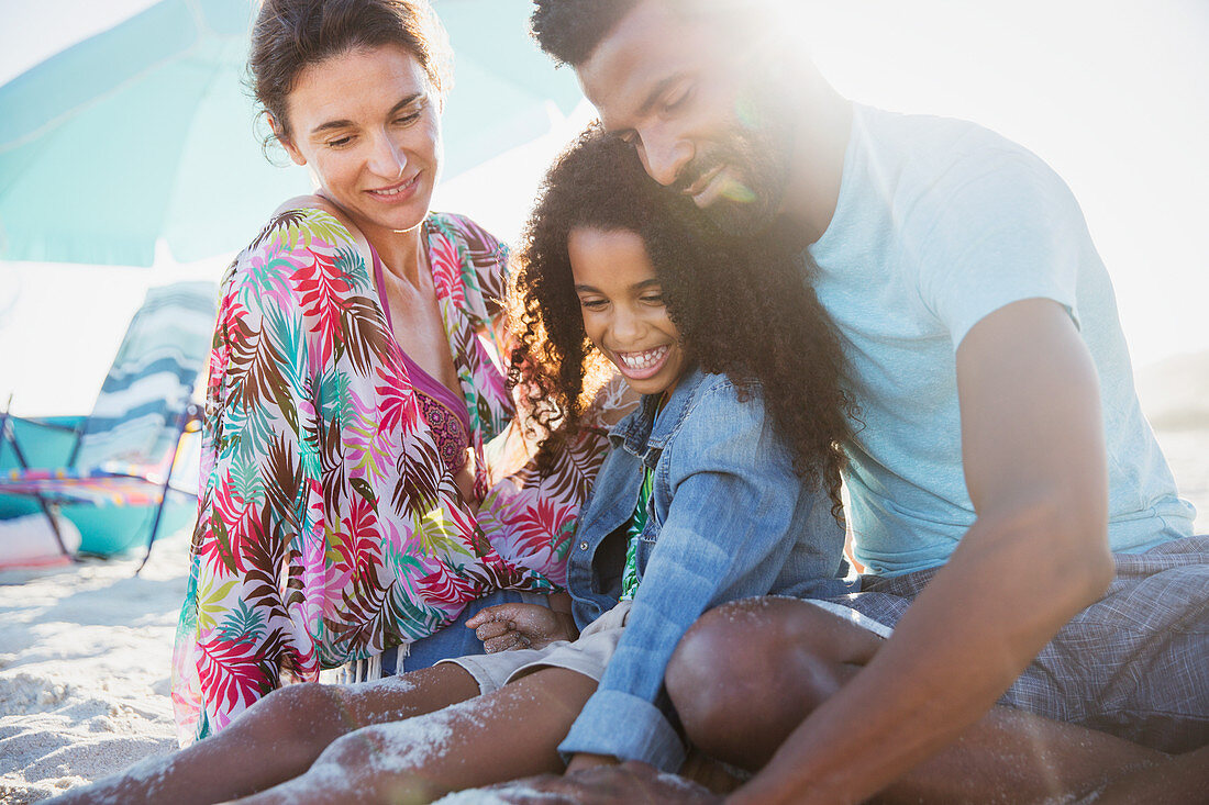 Multi-ethnic family relaxing on sunny summer beach