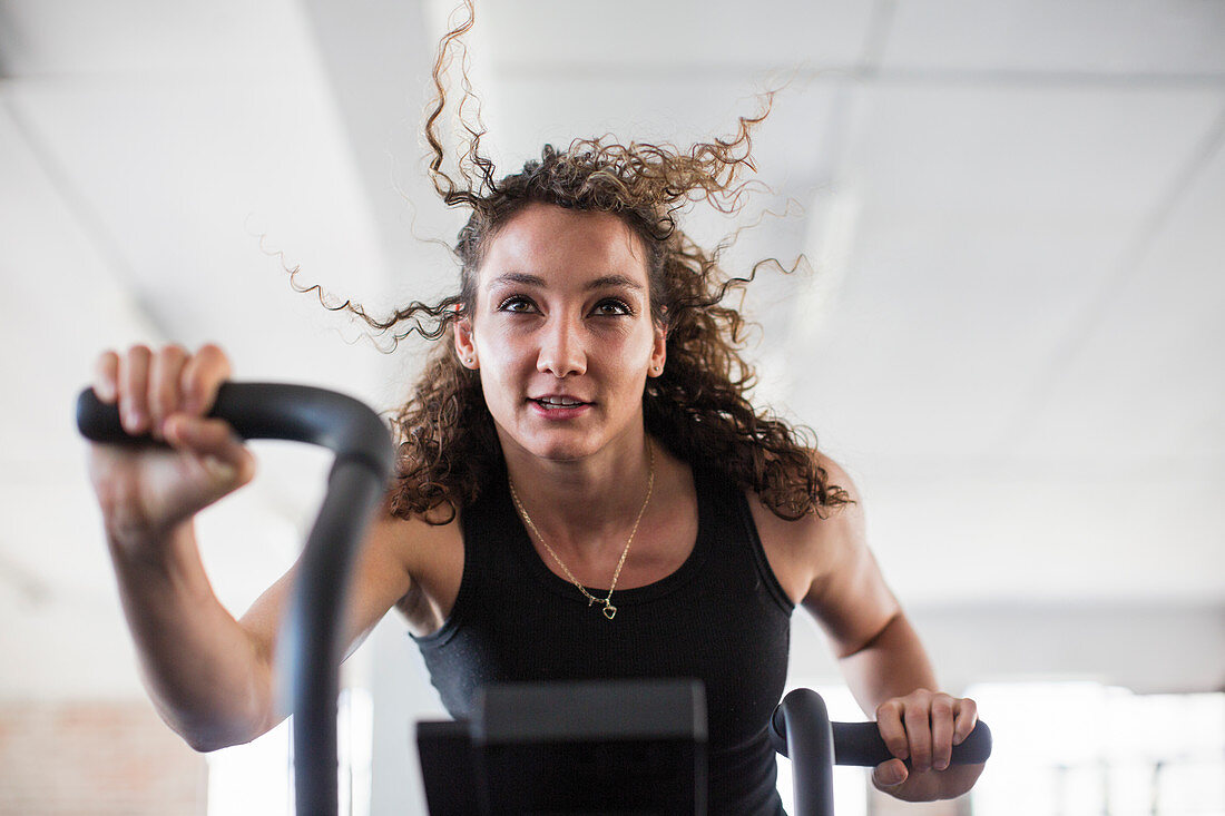Determined woman using elliptical trainer