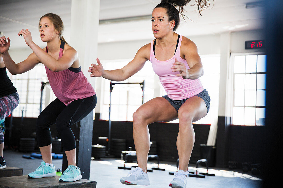 Determined women doing jump squats
