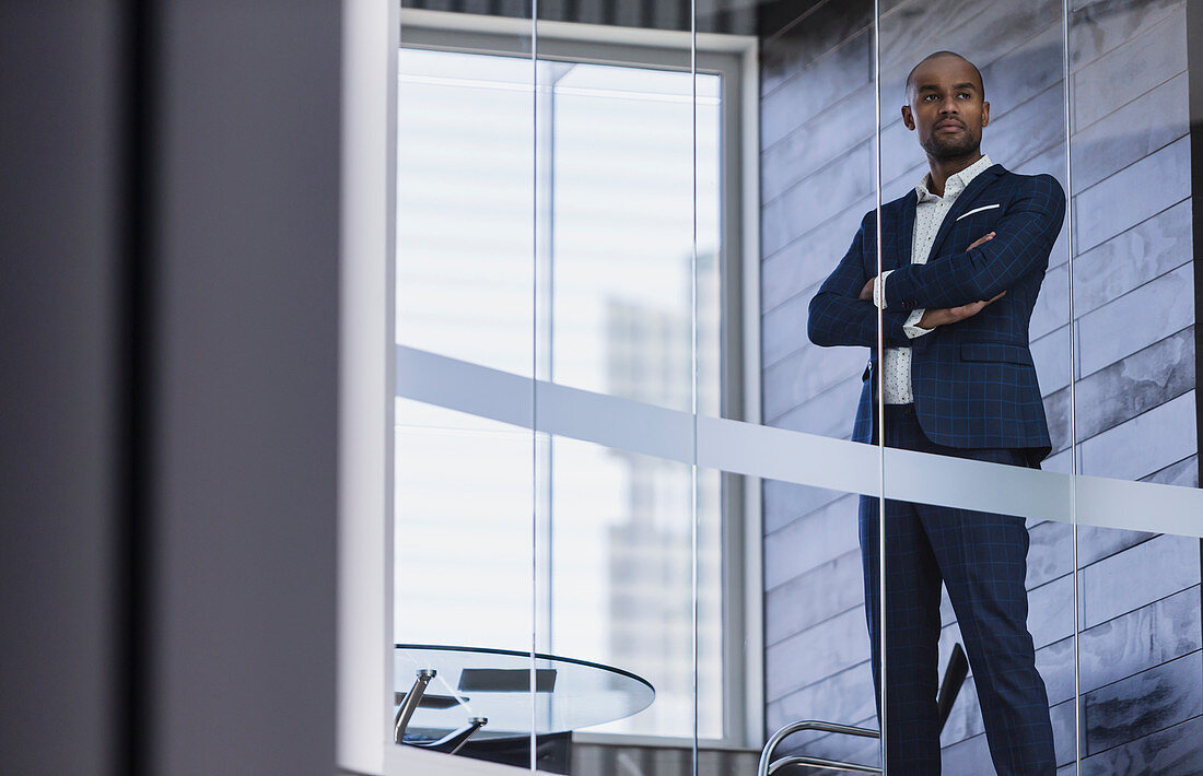 Serious CEO businessman standing at window