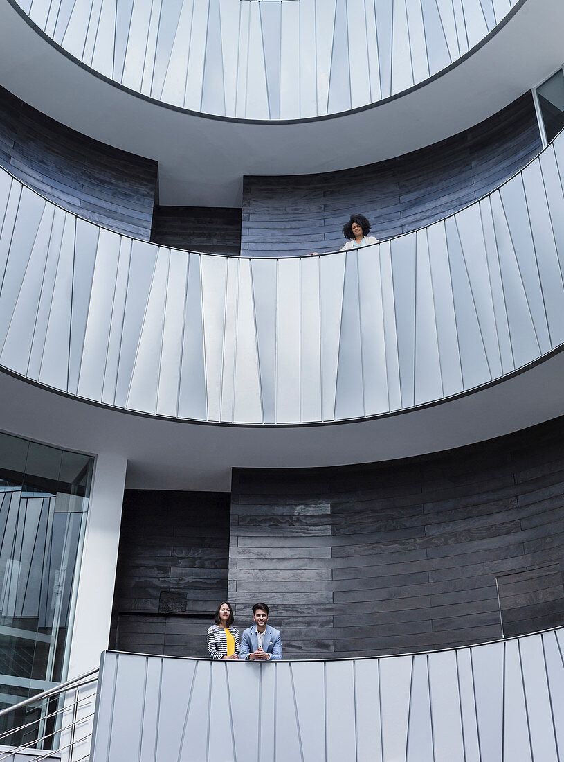 Business people standing on modern balconies