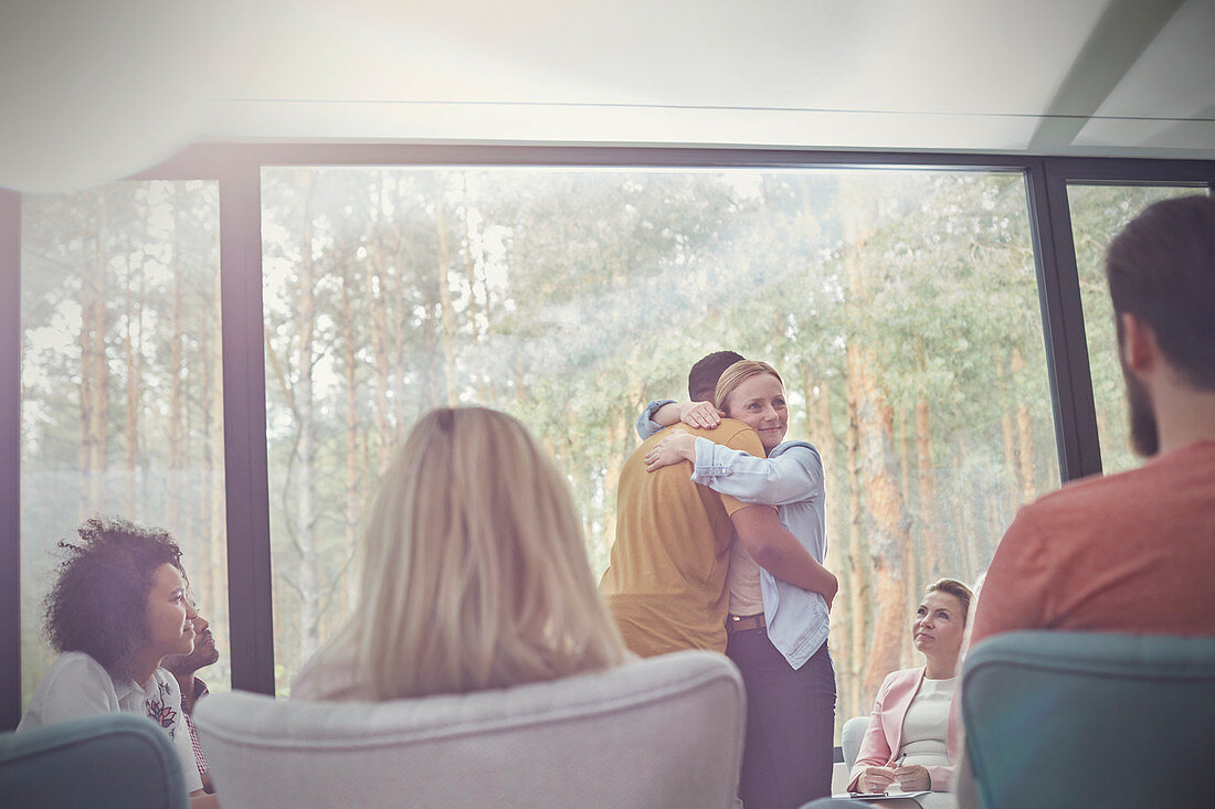 Man and woman hugging in group therapy session