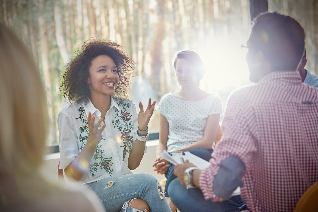 Smiling woman gesturing in group therapy session