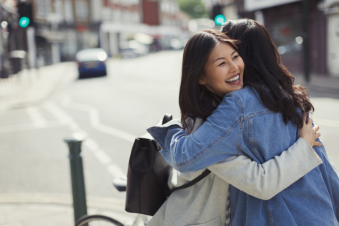 Smiling affectionate female friends hugging