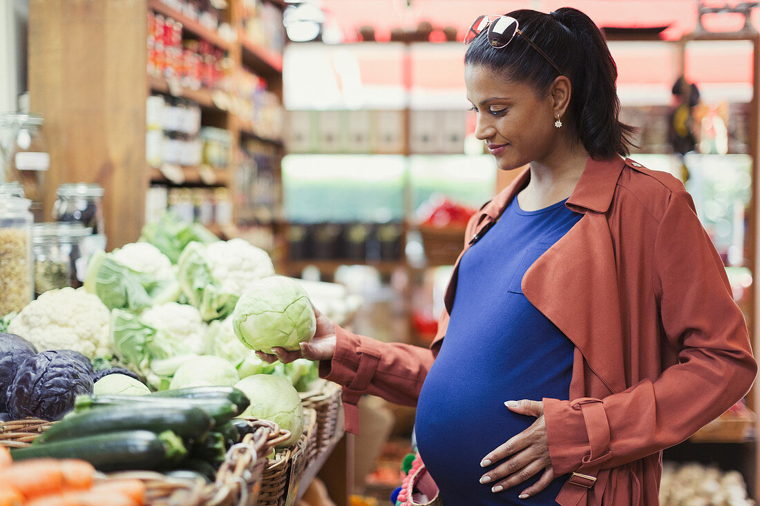 Pregnant woman shopping for cabbage