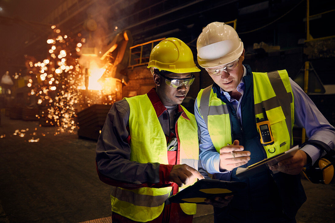 Steelworkers using digital tablets in steel mill