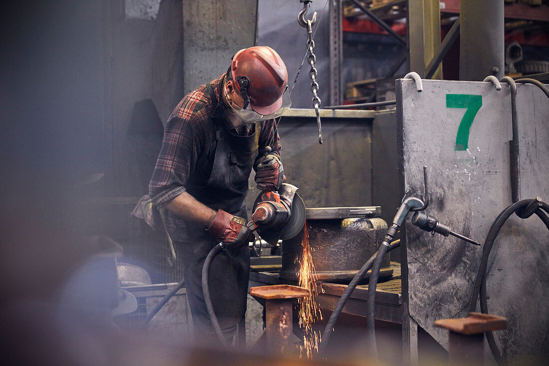 Steelworker using lathe in steel mill