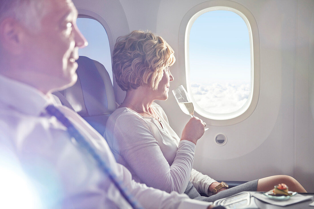 Woman drinking champagne at airplane window