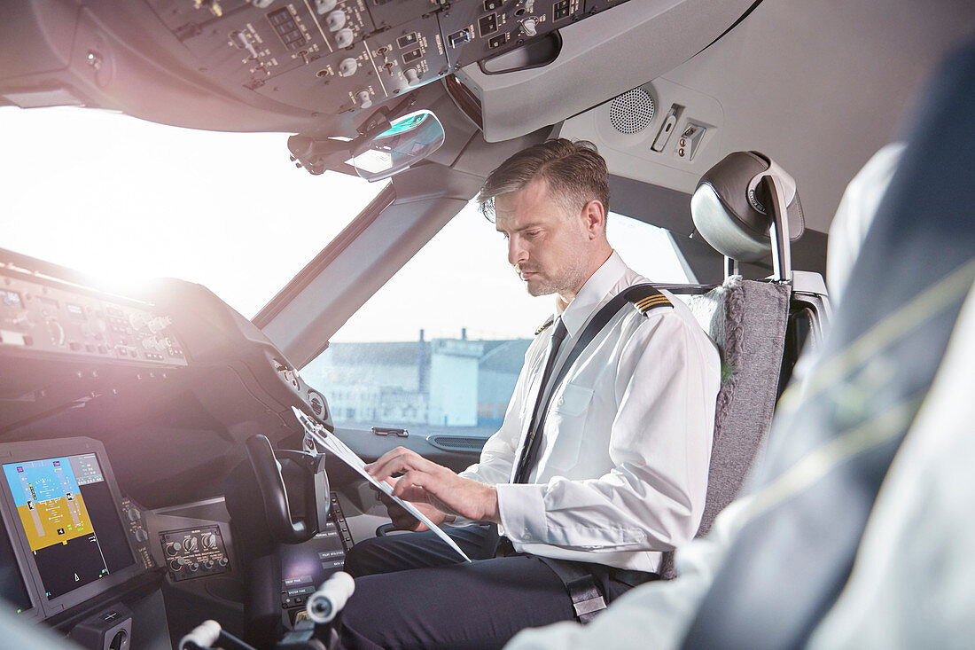 Male pilot preparing in airplane cockpit