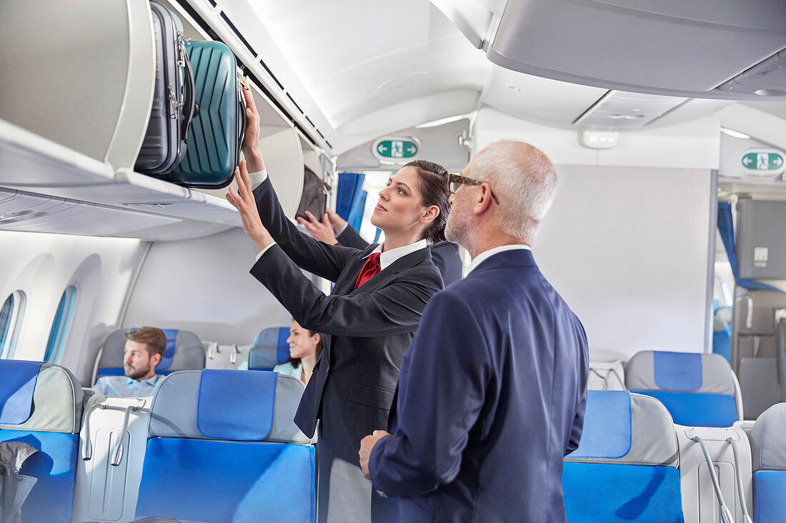 Flight attendant helping businessman