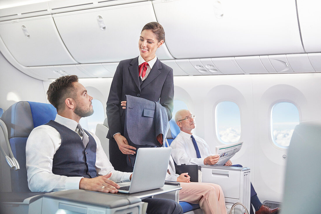 Flight attendant talking with businessman working