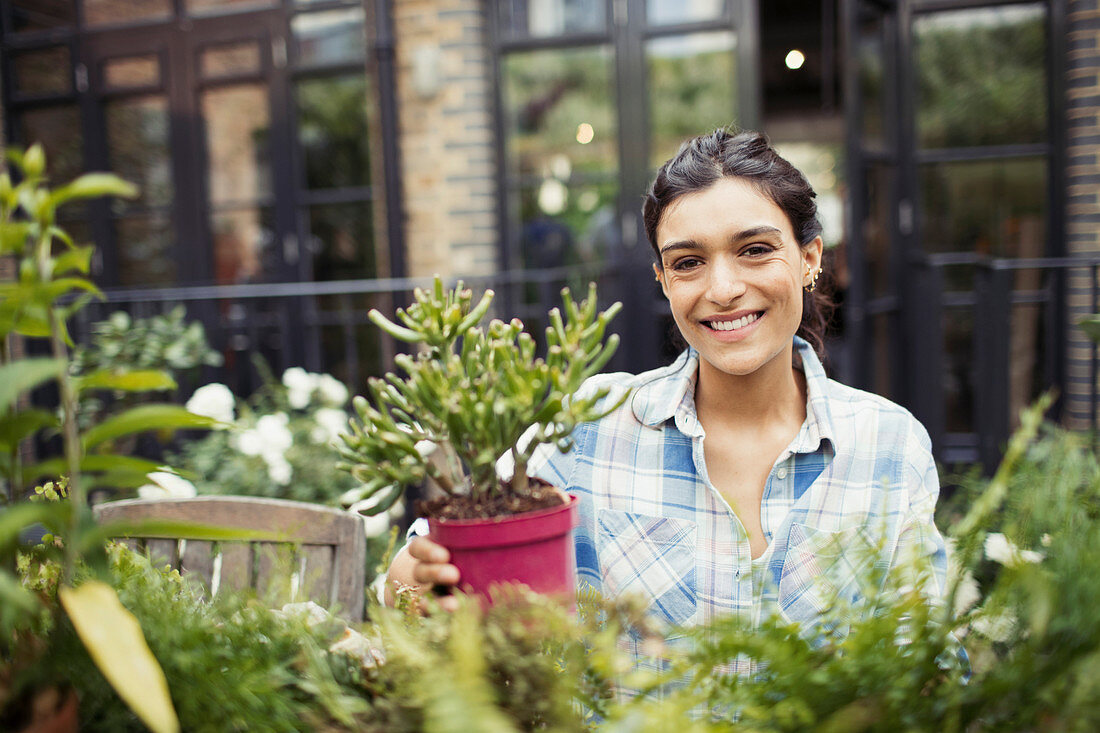 Portrait woman gardening with potted plants