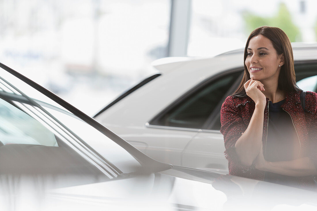 Smiling customer eyeing car in showroom