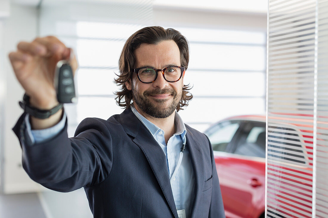 Portrait car salesman holding, showing car key