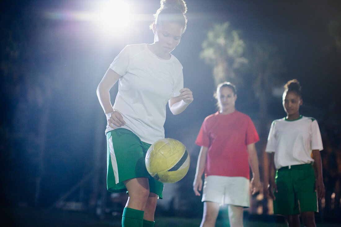 Soccer player practicing, kneeing the ball