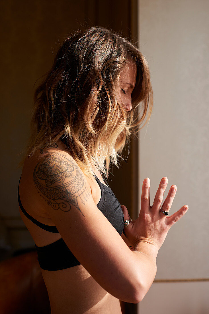 Serene woman with tattoo meditating