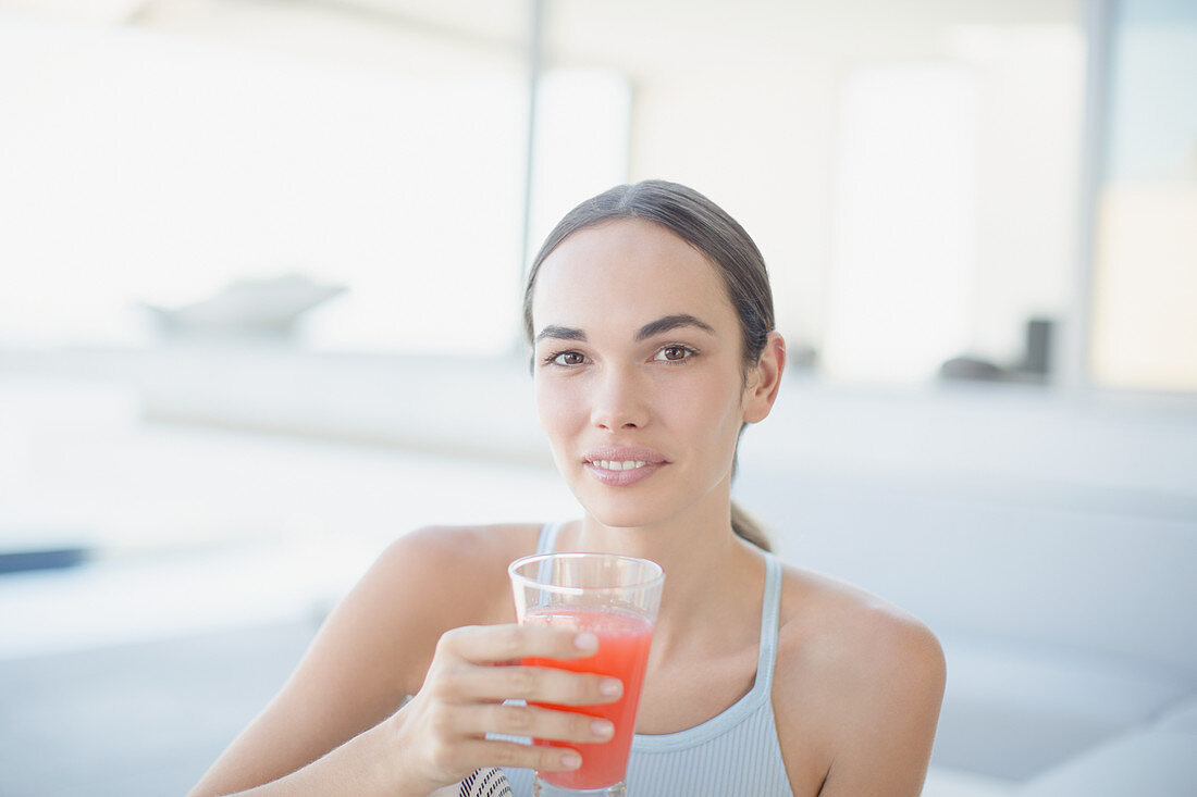 Confident brunette woman drinking juice