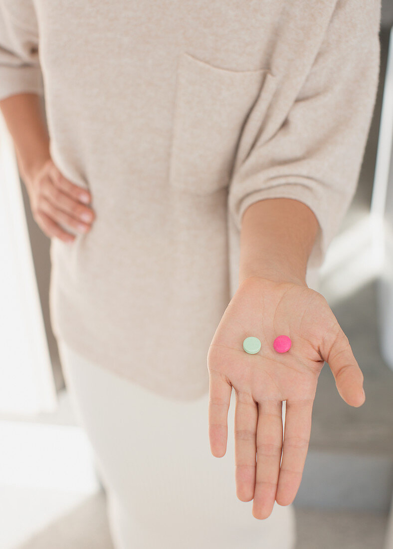 Woman holding two pills