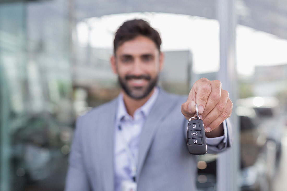 Portrait car salesman holding, showing car keys