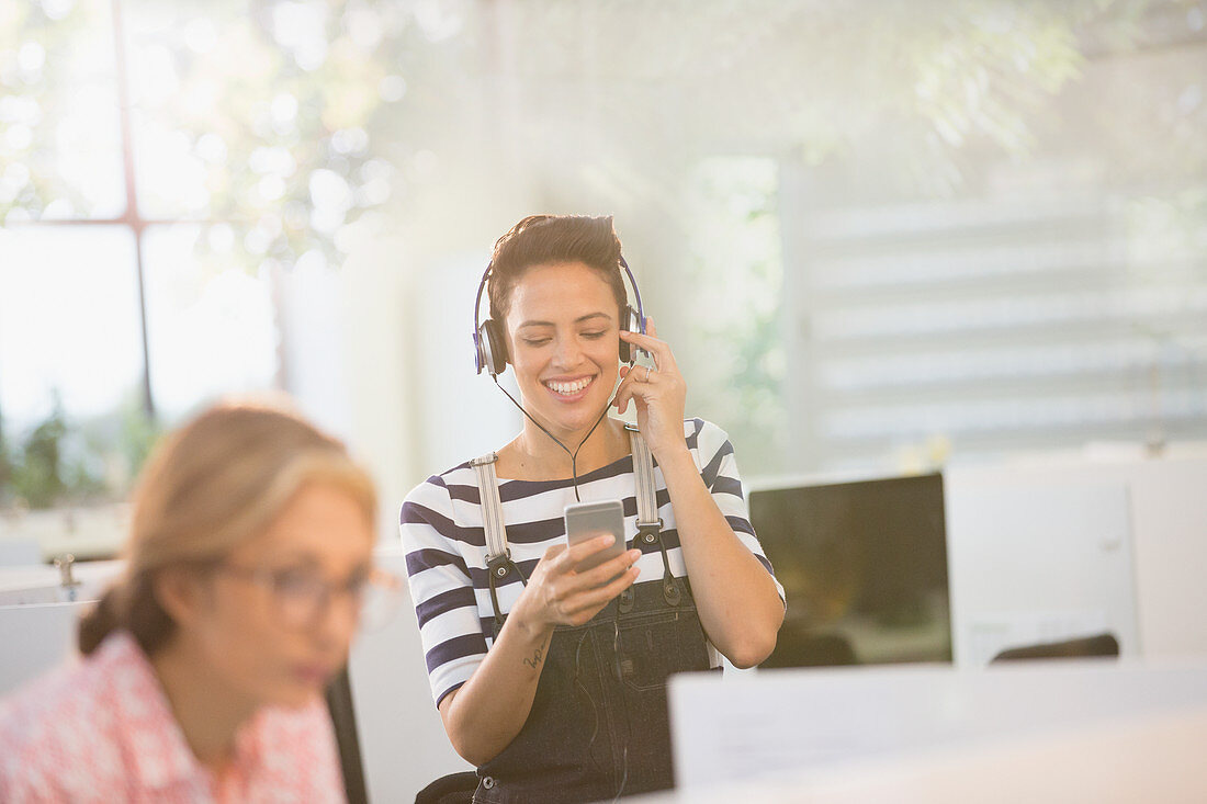 Businesswoman listening to music with smartphone