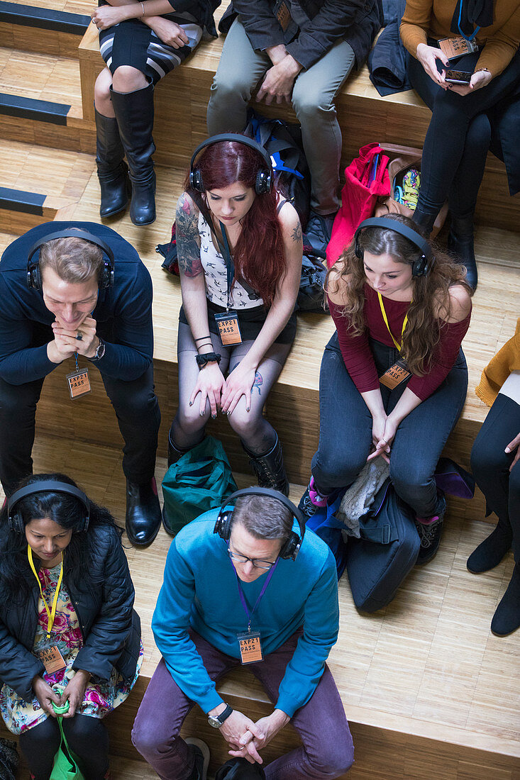 Overhead view audience listening with headphones