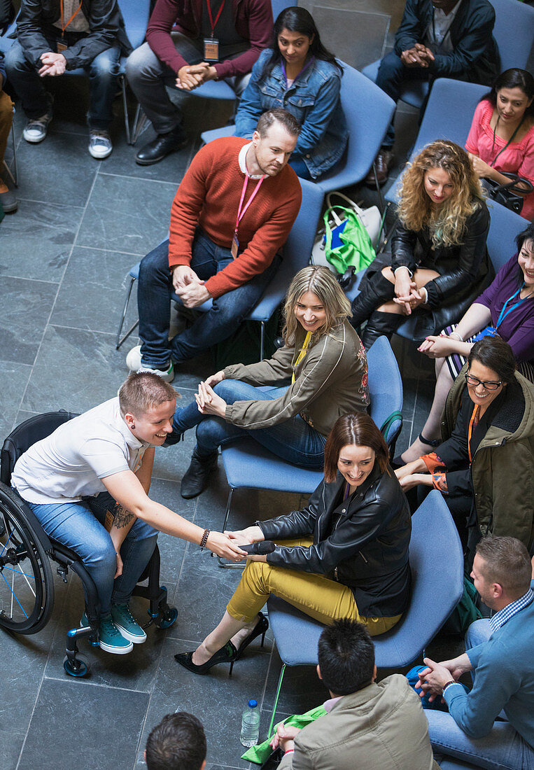 Female speaker in wheelchair giving microphone