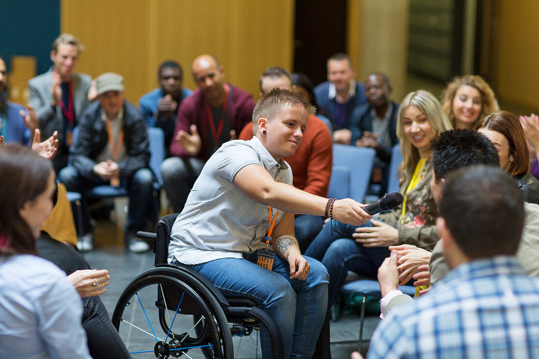 Female speaker in wheelchair giving microphone