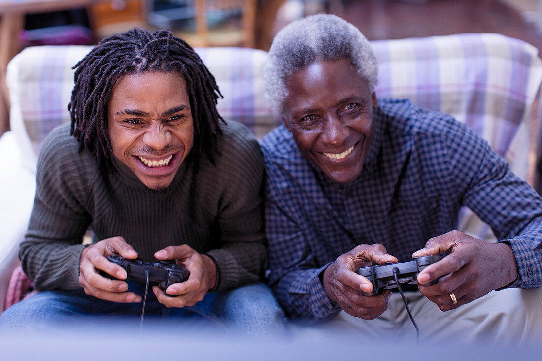 Happy grandfather and grandson playing video game