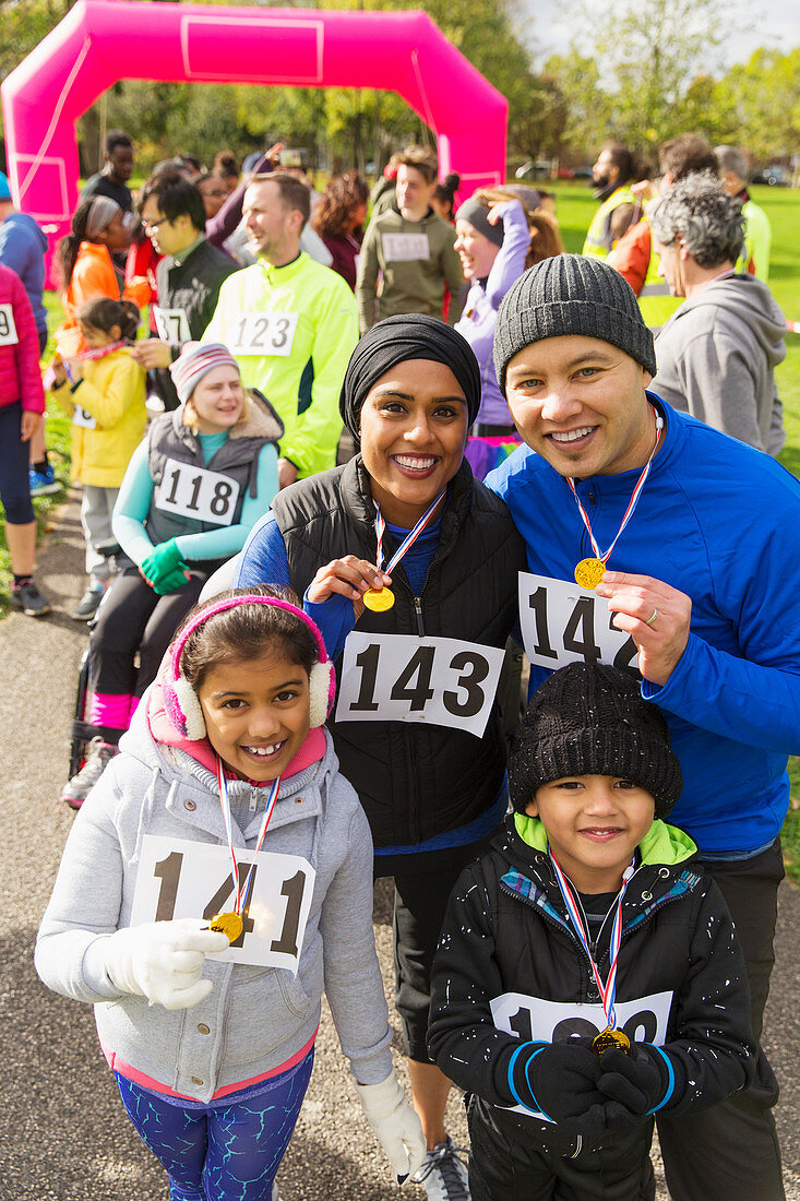 Portrait smiling family with medals at charity run