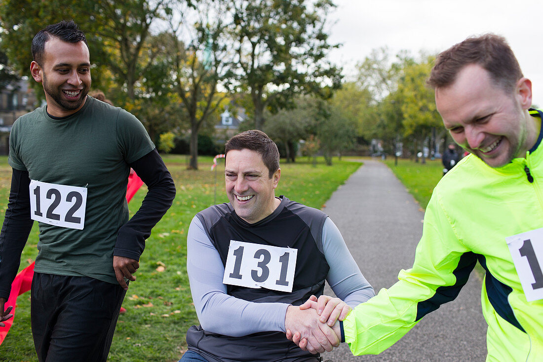 Runner shaking hands with friend in wheelchair