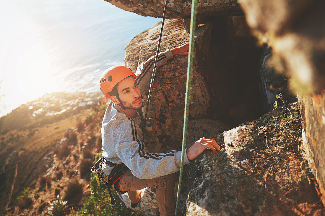 Focused male rock climber climbing rock