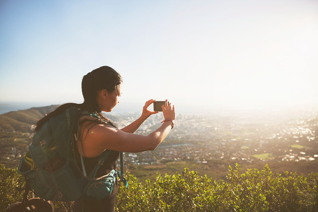 Female backpacker photographing sunny city view