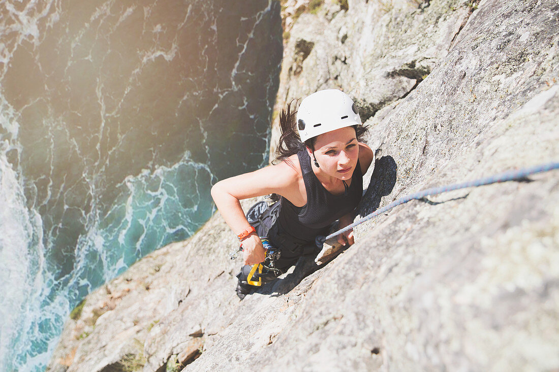 Focused, determined rock climber scaling rock