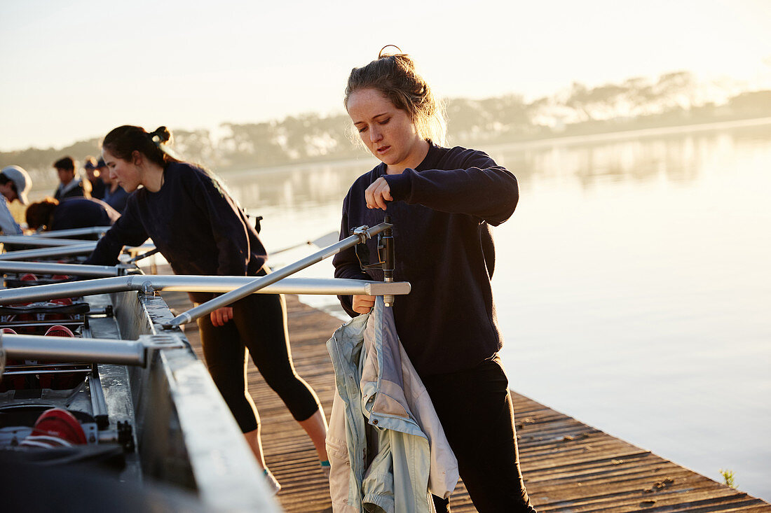 Female rowers preparing scullside dock