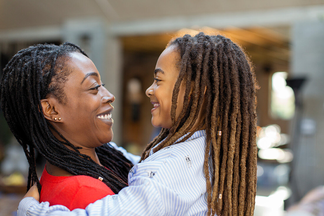 Happy mother and daughter hugging face to face