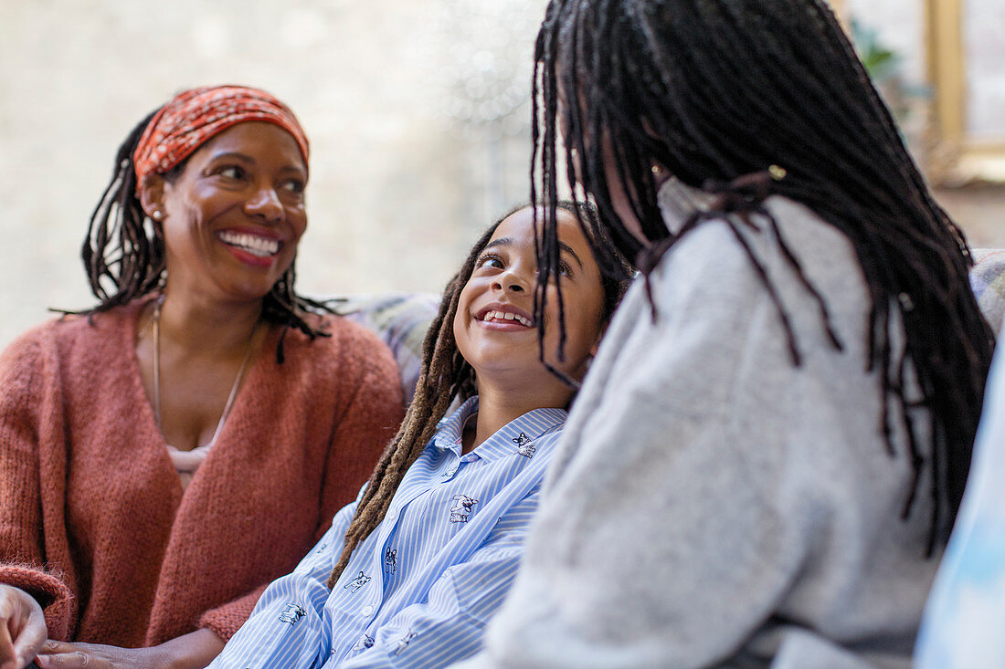 Smiling mother and daughter on sofa