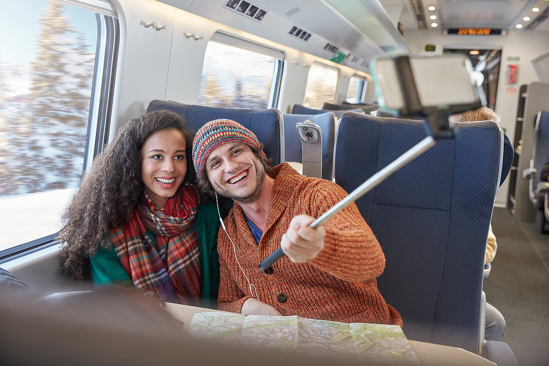 Happy young couple taking selfie on train