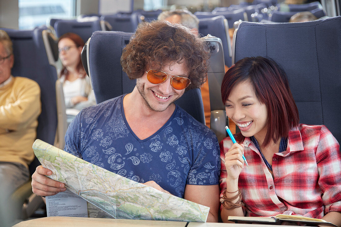 Young couple looking at map on train