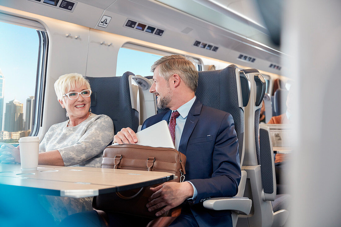 Businessman and businesswoman working on train