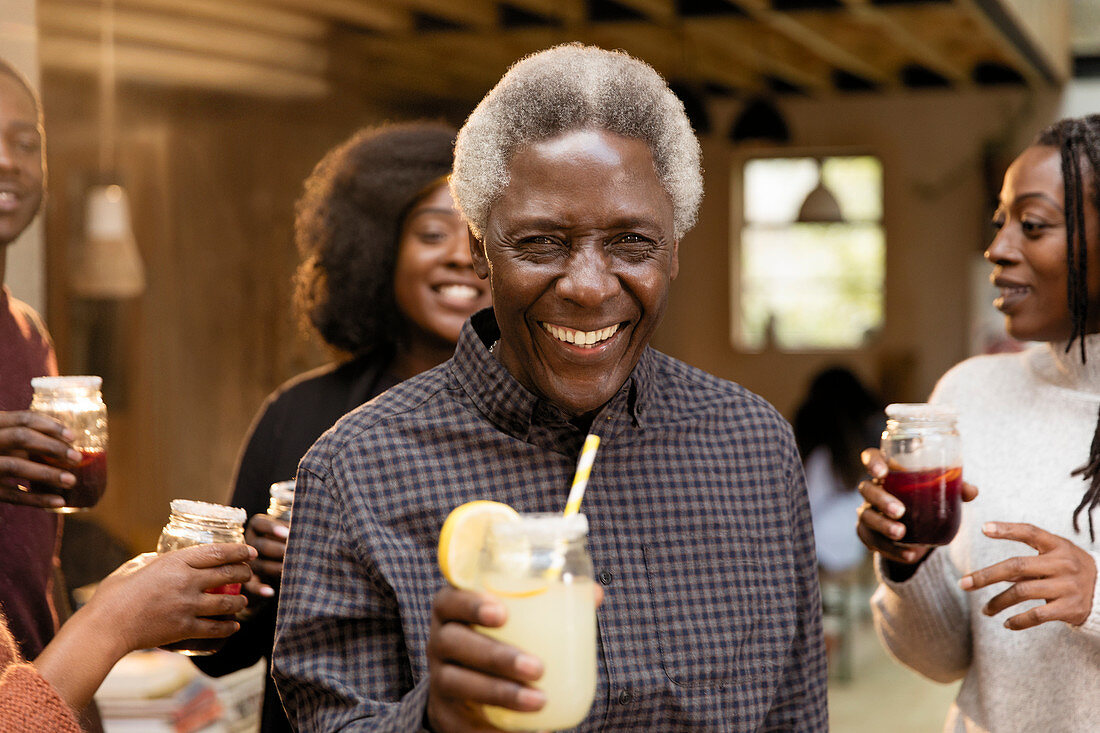 Portrait senior man drinking lemonade with family