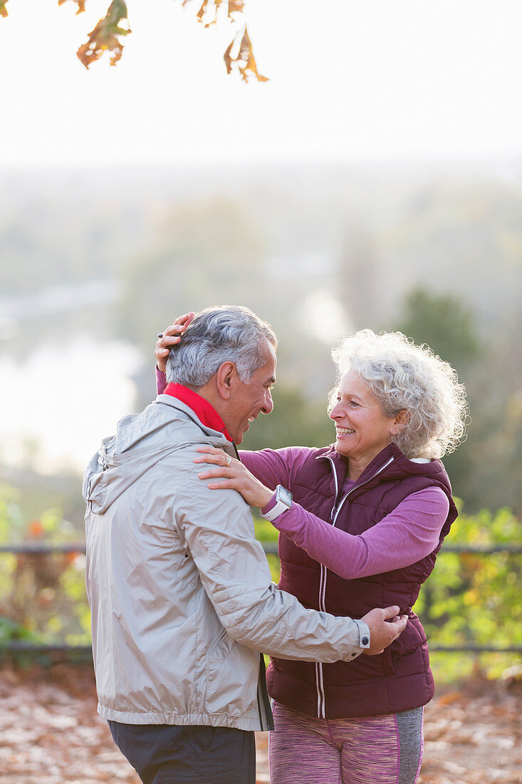 affectionate active senior couple hugging