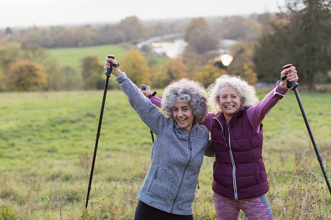 Senior women friends hiking with poles