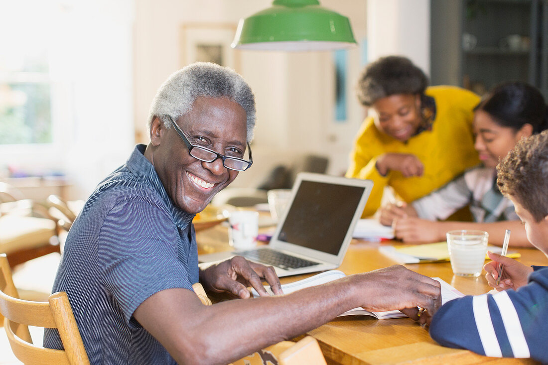 Portrait smiling, senior man using laptop with family