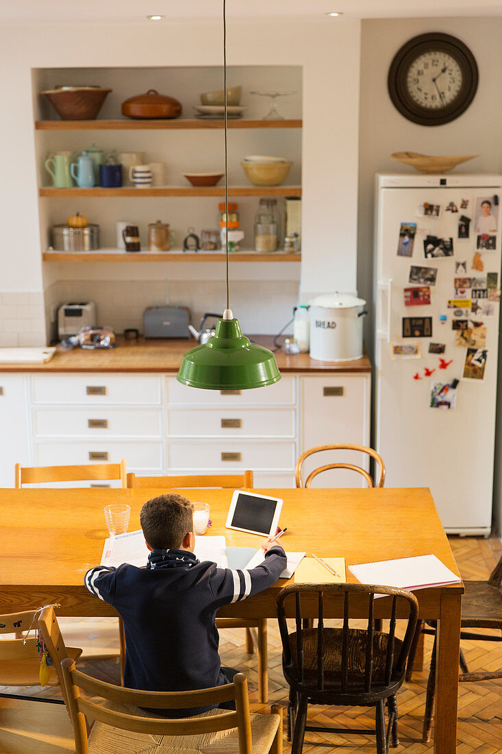 Boy doing homework at dining table