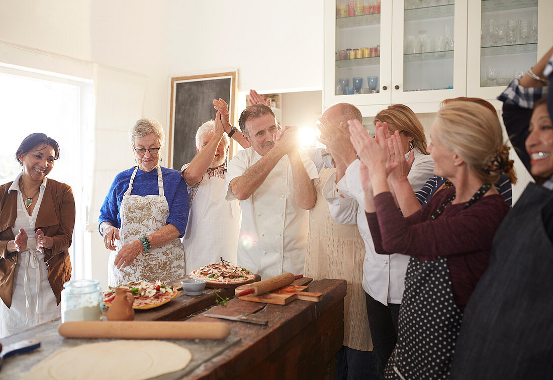 Chef and active senior friends clapping